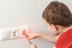 托德勒触动了电源插座。家中有电的危险儿童游戏