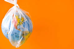 全球形式的球在一个塑料袋里。地球塑料污染的概念。世界环境日的概念。玩具世界在白色塑料袋中的全球。复制文本的空间。拯救地球
