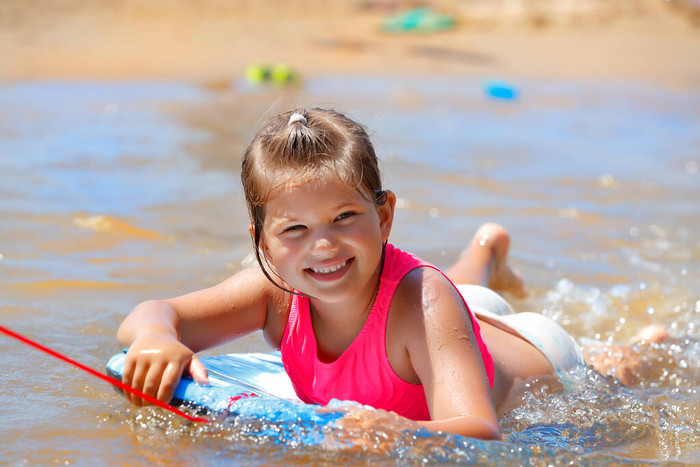 一个可爱的小女孩在海滩上玩乐的肖像漂亮的