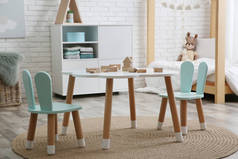 儿童房里有小桌子和有小兔子耳朵的椅子。室内设计
