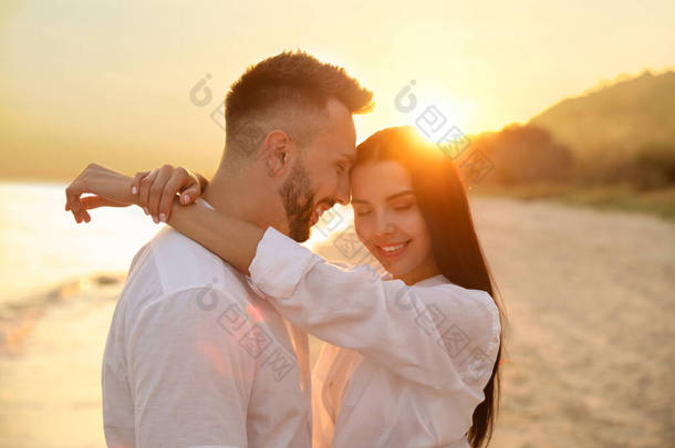 日落时分，一对年轻夫妇在海滩上欢<strong>欢喜</strong>喜