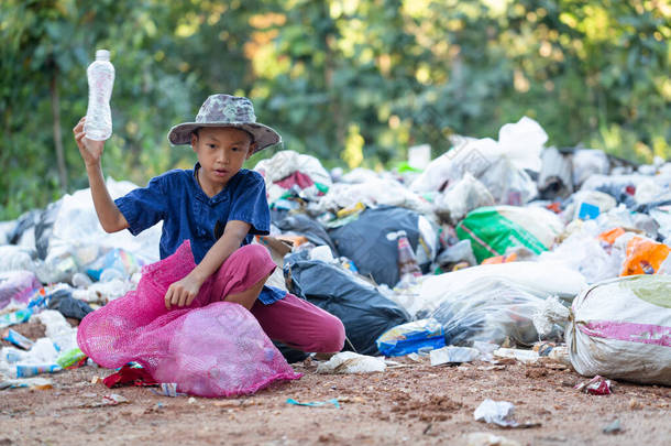 一个从垃圾填埋场收集垃圾的穷小子<strong>贫困儿童</strong>的生计概念。童工。童工、贩运人口、贫穷概念