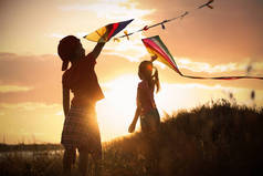日落时，小孩子们在户外玩风筝。在性质上花费的时间