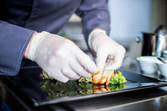 特写厨师用鳗鱼黄瓜和生菜叶在垫子上做沙拉