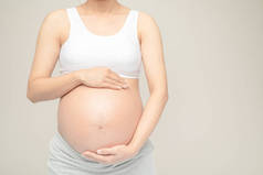 怀孕的女人摸她的大肚子。靠近点母亲、怀孕、人和期望的概念。怀孕妇女怀孕分娩