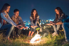 那些在篝火边取暖的年轻人点亮了城市的背景。夜间作业