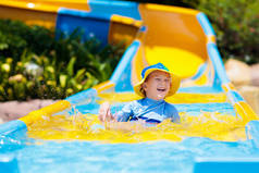 孩子们在水上公园滑水。在热带度假胜地的家庭暑假里，孩子们在滑水上玩得很开心。幼童及幼童游乐场休憩公园.