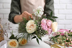 花匠在白桌旁做漂亮的花束，特写