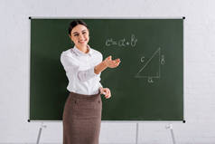 数学课期间，教师用手靠近黑板微笑