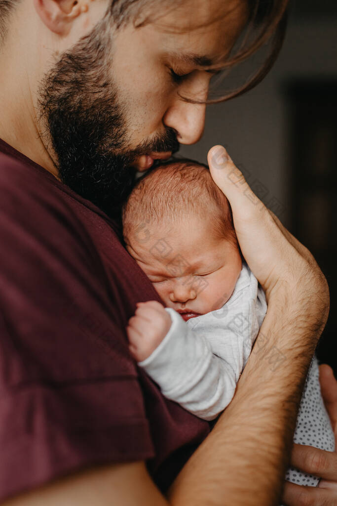 在父亲怀里抱着一个新生婴儿的家庭照片选择