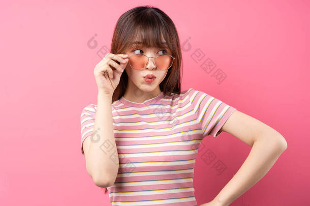 身穿粉色背景的粉色T恤的年轻亚洲女孩形象