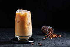 在深色背景下的高玻璃杯中加奶的冰镇咖啡。概念更新夏季酒水