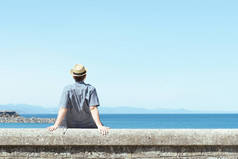 在阳光明媚的夏日，孤独地坐在后排，凝视着海滨的地平线.