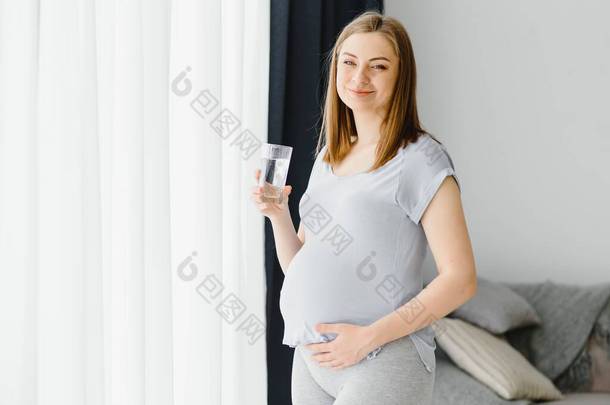一个可爱的孕妇喝水的肖像
