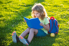 一本关于草地背景的漂亮的童书.孩子们在公园看书。学习概念.