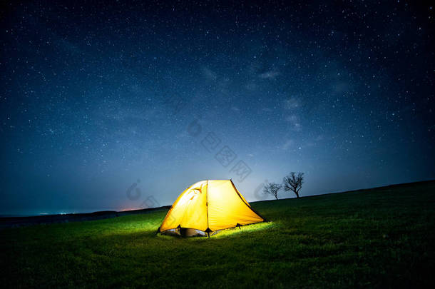 星光灿烂的天空下, 夜晚群山中闪耀的露营帐篷