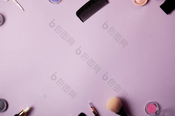 在紫色背景下的各种化妆工具和化妆品的顶级视图
