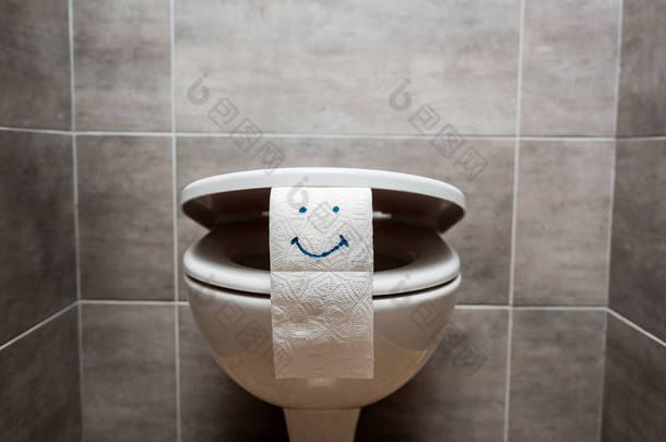 现代卫生间的陶瓷清洁马桶和面带微笑的卫生纸