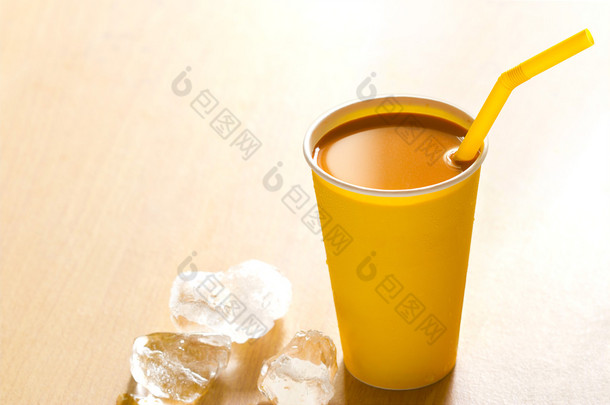 在纸杯和木制的背景下，温暖的色调上的冰奶茶