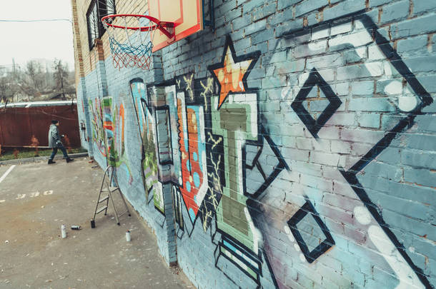 男子在墙上用<strong>篮球</strong>圈画彩色<strong>涂鸦</strong>