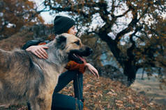 快乐的女人徒步旅行的女人抱着狗外出旅行友谊