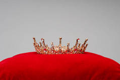 红色天鹅绒衬垫上的豪华王冠，灰色隔离