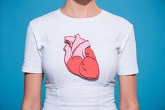 裁剪拍摄的妇女在白色 t恤与纸的心脏在蓝色的背景