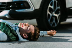 交通碰撞后躺在路上的受伤青年的侧视图