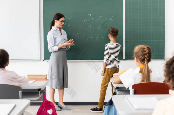 数学课期间，师生和多民族<strong>同学</strong>在黑板上解题方程的回顾
