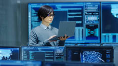 在系统控制室中, It 技术人员在笔记本电脑上保存和工作, 在后台多个显示图形。人工智能、大数据挖掘、神经网络、监控项目的设施工程.