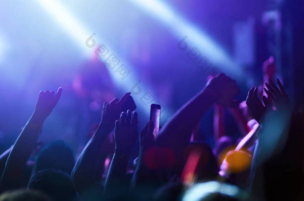 观众<strong>举手</strong>在音乐节和灯光从舞台上方流下。 群众<strong>举手</strong>，跳舞，欣赏音乐会.