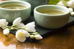 绿茶与茉莉花在杯子和木桌上的茶壶