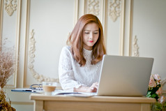 美丽的商业女性使用一台笔记本电脑