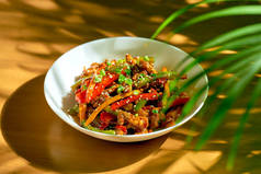 牛肉在甜酸的酱汁中打滚,蔬菜和四川胡椒放在一个碗里.中国菜