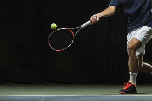 在网球比赛中拍拍网球球拍的男人的照片