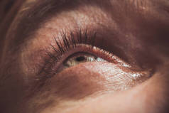 一个男人用鲜红的动脉滴开人眼，以改善视力。刺激和红眼。学生，虹膜，睫毛在宏观。视力问题