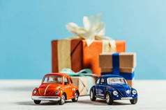 特写镜头的玩具汽车与圣诞礼品盒在蓝色背景