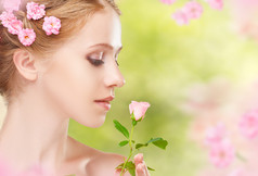 美脸的年轻美丽的女子和粉色的花朵在她哈哈