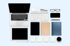 平躺照片的办公桌上有笔记本电脑, 数码片, 手机和配件。在现代背景下。台式机办公室样机概念.