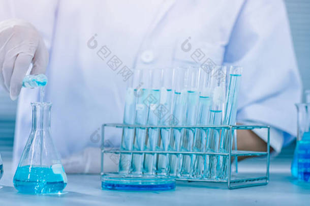 科学家手握瓶，用化学液体滴入试管，科学与医学研究与发展理念