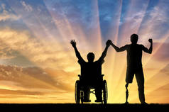 残疾人士与假肢和轮椅持手日落
