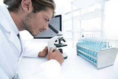 年轻的实验室位科学家在实验室的显微镜观察
