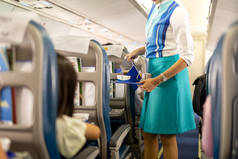 飞机乘务员为乘客提供饮品.
