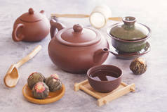 绿茶芽, 棕色陶瓷茶壶, 为一个传统的亚洲茶道站在一个灰色的表准备一个杯子