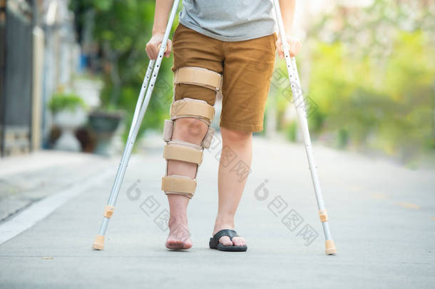 带<strong>拐杖</strong>或<strong>拐杖</strong>或膝盖支撑的残疾妇女