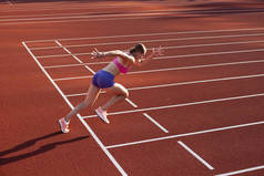 在起跑线上一名白人妇女，女运动员，在公共体育场、运动场或室外跑道进行跑步训练。夏季运动会.