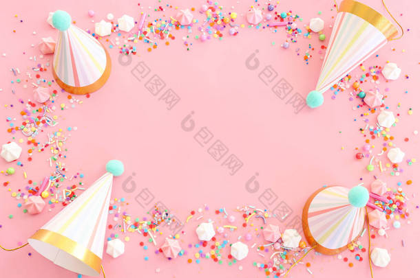 <strong>生日宴</strong>会背景,帽子和彩色糖果盖在粉红的粉红背景之上.顶部视图
