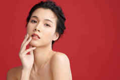美丽的年轻亚洲女人，有着鲜红的背景、脸蛋护理、面部护理、美容美发、美容美发、水疗、亚洲女性肖像.