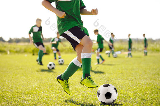 草地上的男孩跑得快，跳跃和踢球。足球训练队。<strong>青少年</strong>足球队训练<strong>夏令营</strong>