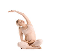 在白人背景下练习瑜伽的年轻孕妇